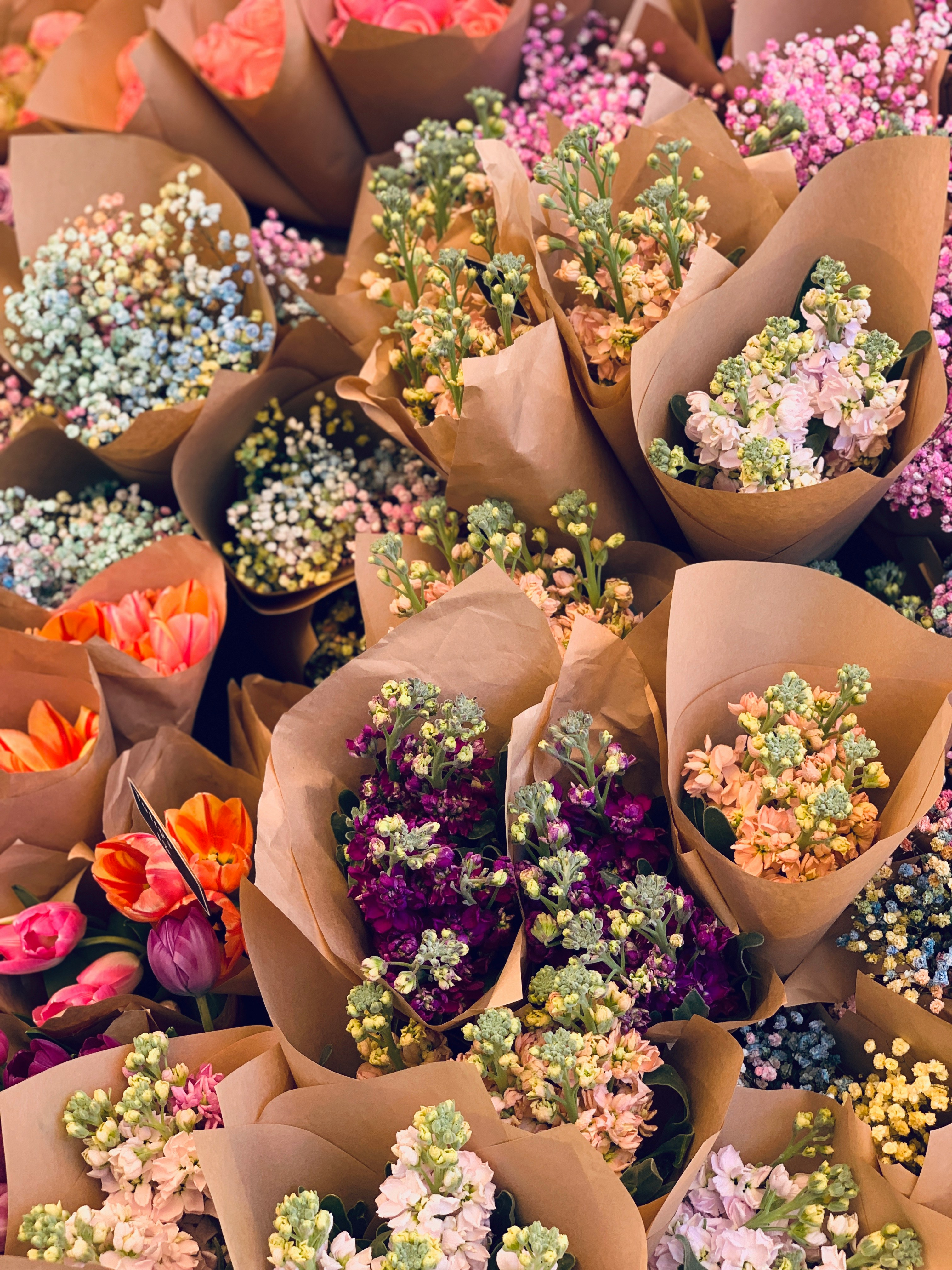 floral artist in workroom making a bouquet surrounded by flowers